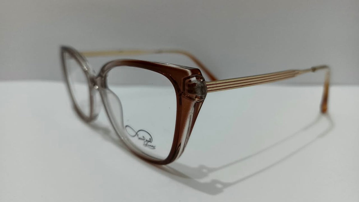 Three-quarter view of translucent brown cat-eye eyeglasses with striped gold-tone temples