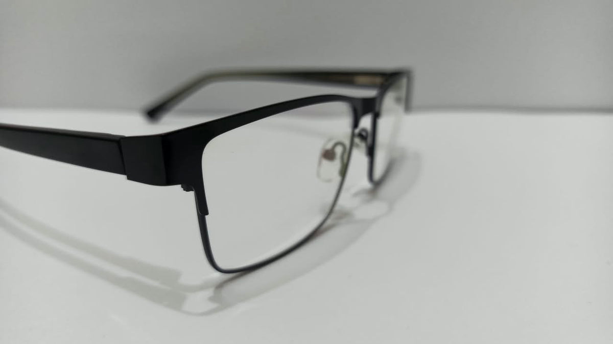Angled view of shiny black semi-rimless rectangular eyeglasses