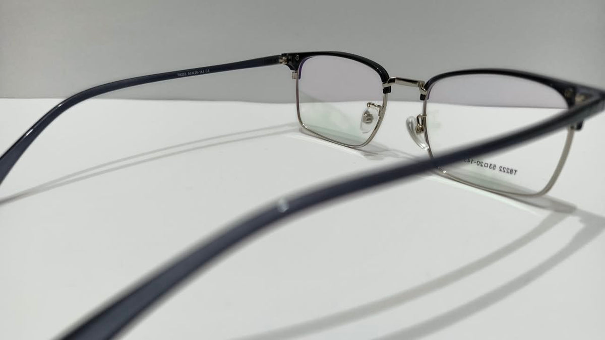 Angled side view of black and gold half-rim eyeglasses